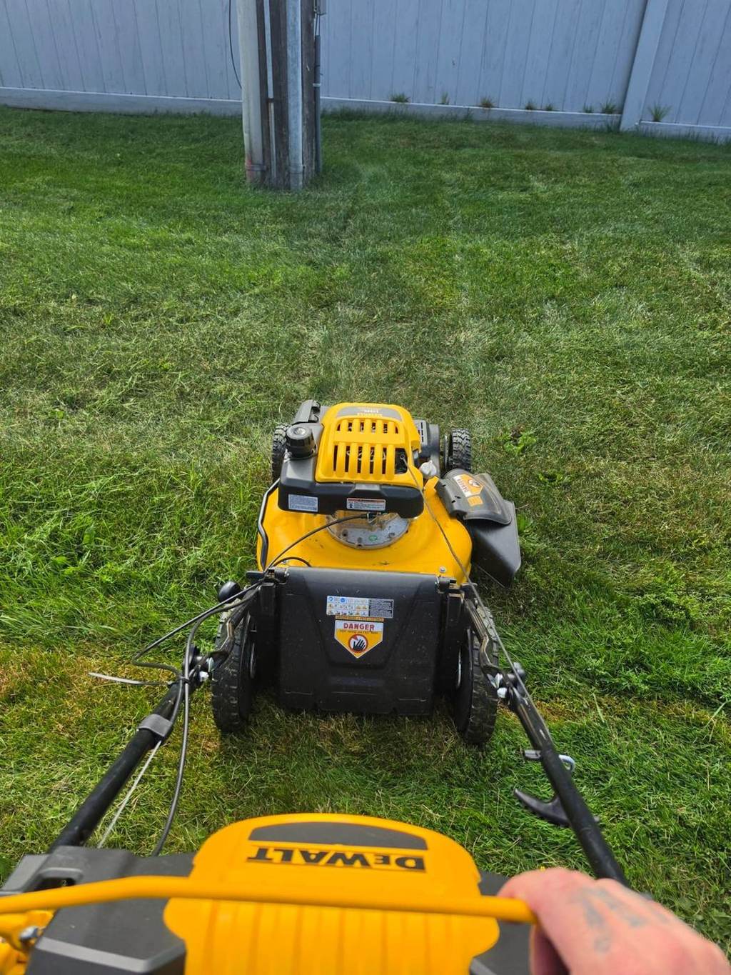Benny's Lawn Care grass cutting service in progress with a walk-behind mower on an Ottawa back lawn